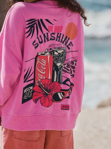 Next Collegepaita 'Coca-Cola Summer' värissä vaaleanpunainen