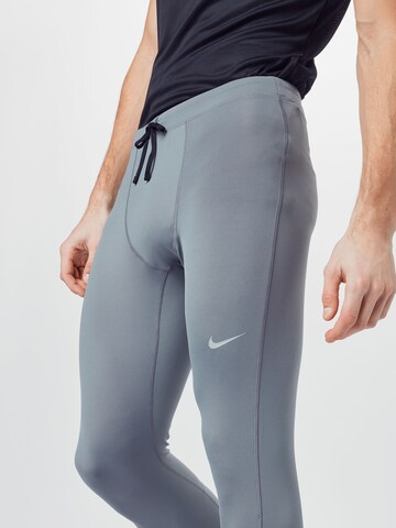 NIKE Skinny Urheiluhousut 'Challenger' värissä harmaa