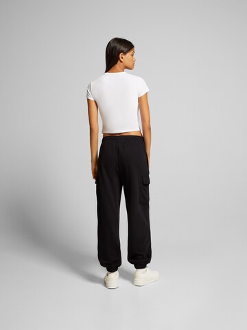 Bershka Tapered Byxa i svart