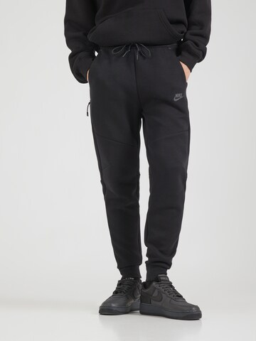 juoda Nike Sportswear Siaurėjantis Kelnės 'TCH FLC': priekis