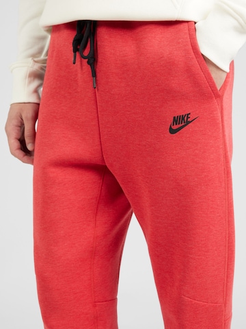 Nike Sportswear Tapered Housut 'TECH FLEECE' värissä punainen