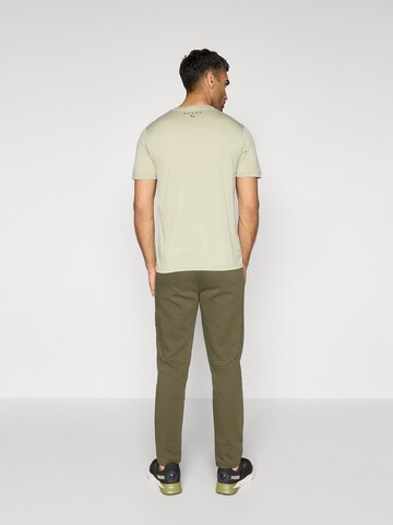 PUMA Slimfit Urheiluhousut 'Evostripe' värissä vihreä