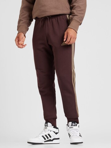 ADIDAS SPORTSWEAR - Tapered Calças de desporto 'Essentials' em castanho: frente