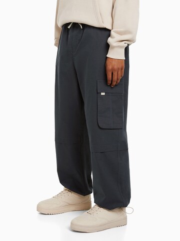 Bershka Loose fit Cargo trousers in Grey: front