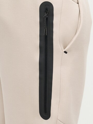 Nike Sportswear Zwężany krój Spodnie 'Tech Fleece' w kolorze beżowy