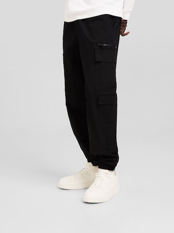 Bershka Tapered Cargo Pants in Black: front