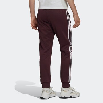 ADIDAS ORIGINALS Tapered Trousers in Red