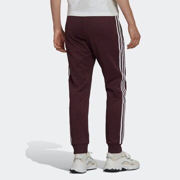 Effilé Pantalon ADIDAS ORIGINALS en rouge