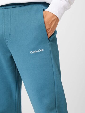 zils Calvin Klein Pakapēniski sašaurināts piegriezums Bikses