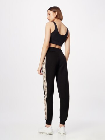 GUESS - Tapered Pantalón deportivo 'Britney' en negro