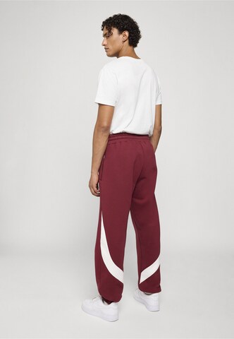 Tapered Pantaloni di Unfair Athletics in rosso