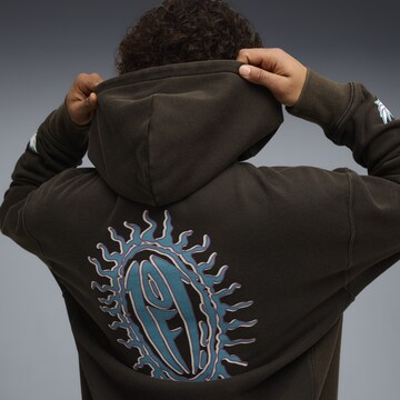 PUMA Sweatshirt 'Melo x Hive' in Schwarz