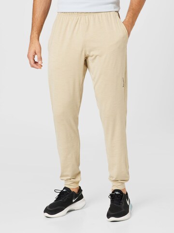 NIKE Tapered Workout Pants in Beige: front