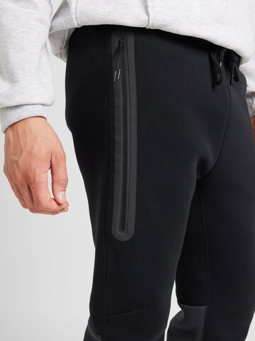 Nike Sportswear Tapered Παντελόνι 'TECH FLEECE' σε μαύρο