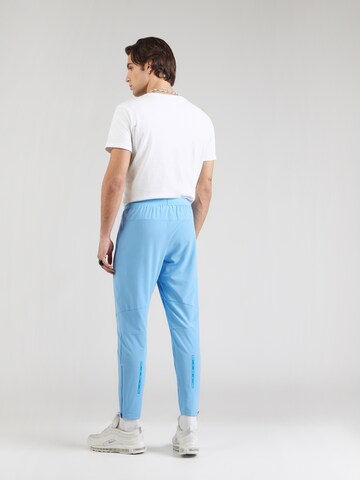 Effilé Pantalon Nike Sportswear en bleu : derrière