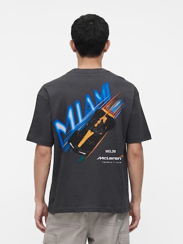 HOLLISTER Majica 'F1 RACING LIC MIAMI MCLAREN' | črna barva: sprednja stran