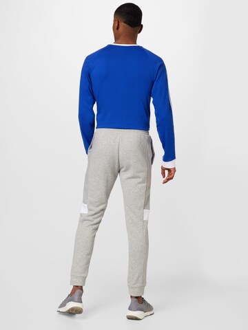 ADIDAS SPORTSWEAR Tapered Urheiluhousut 'Essentials Colorblock' värissä harmaa