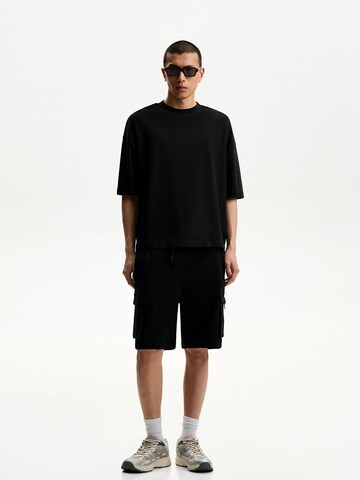 Bershka Loose fit Cargo trousers in Black: front