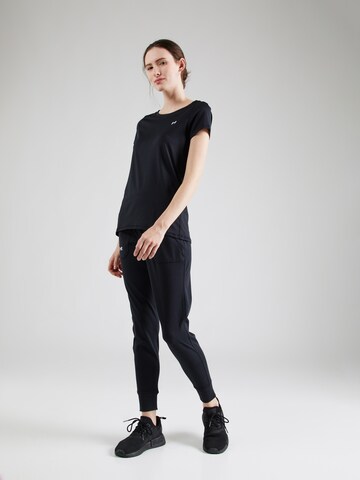 UNDER ARMOUR Tapered Sports trousers 'Motion' in Black