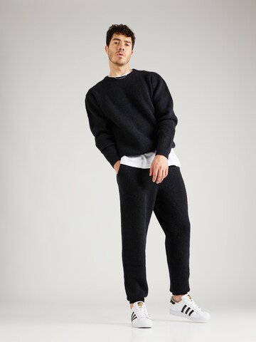 Tapered Pantaloni 'Taylan' di ABOUT YOU x Jaime Lorente in nero