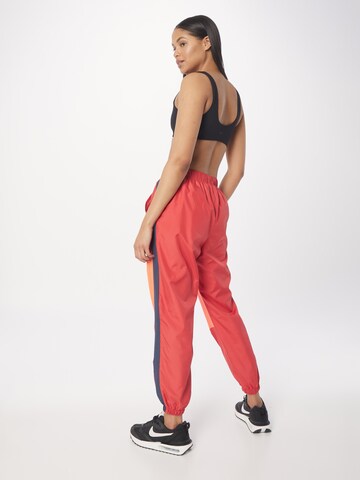 Effilé Pantalon de sport UNDER ARMOUR en rouge