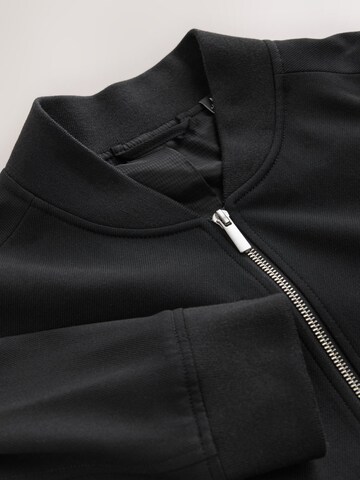 Next - Chaqueta de entretiempo 'Motionflex' en negro