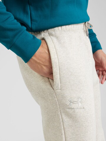 UNDER ARMOUR Zwężany krój Spodnie sportowe 'Essential' w kolorze beżowy