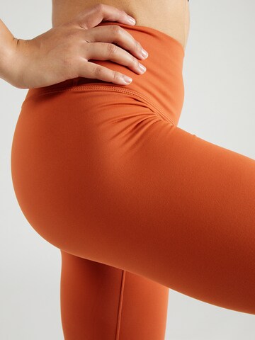 Skinny Pantaloni sportivi 'ONE' di NIKE in arancione