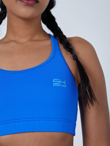 SPORTKIND Medium support Sport bh 'Crossed Straps' in Blauw