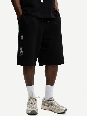 Bershka Loose fit Trousers in Black: front