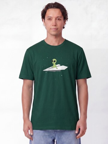 Maglietta 'Alien on a paper plane' di Watapparel in verde: frontale