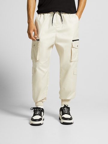 Bershka Tapered Cargo Pants in Yellow: front