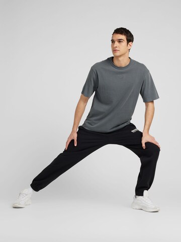 Tapered Pantaloni sportivi 'IDENTITY BRAND PROUD' di Reebok in nero