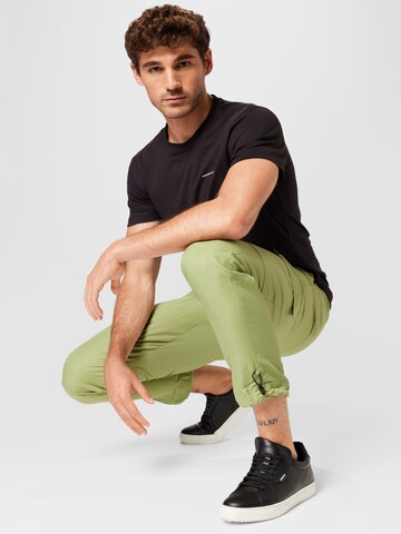 Effilé Pantalon cargo 'REPEAT' Nike Sportswear en vert