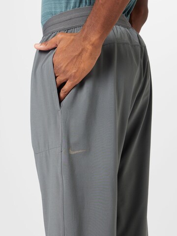 NIKE Tapered Sports trousers in Grey