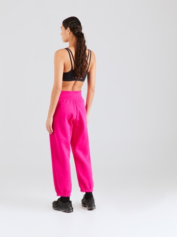 Nike Sportswear Tapered Housut 'PHOENIX FLEECE' värissä vaaleanpunainen