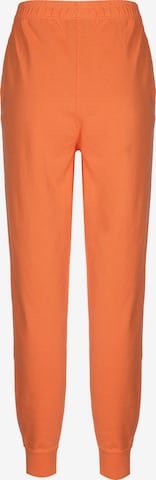 Nike Sportswear Zwężany krój Spodnie w kolorze pomarańczowy
