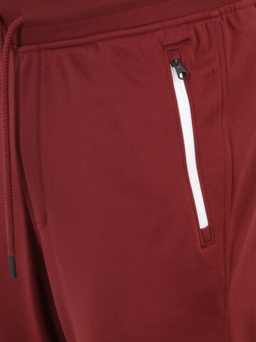 Effilé Pantalon de sport UNDER ARMOUR en rouge