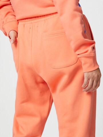 ABOUT YOU x Mero Lużny krój Spodnie 'Code' w kolorze pomarańczowy