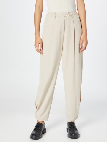 Karo Kauer Tapered Pleat-Front Pants in Beige: front
