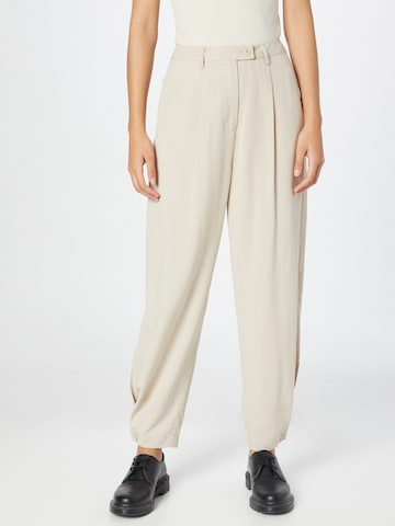 Karo Kauer Tapered Pleat-front trousers in Beige: front