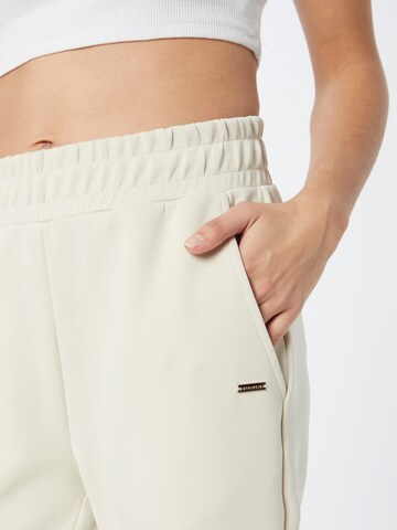 Athlecia - Tapered Pantalón deportivo en beige