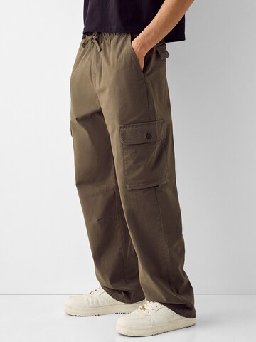Bershka Loose fit Cargo trousers in Brown: front