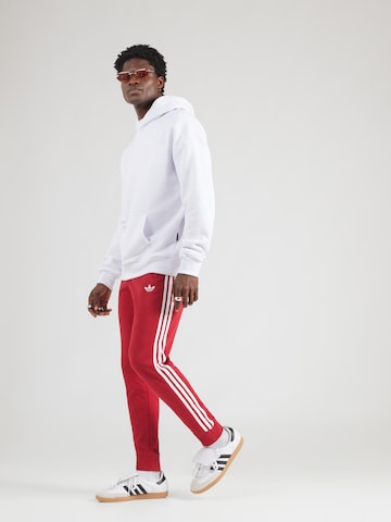 ADIDAS ORIGINALS - Tapered Calças em vermelho