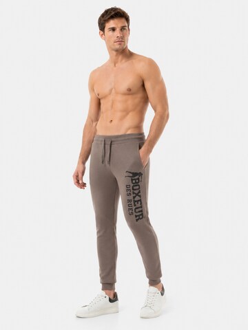 Boxeur des Rues - regular Pantalón deportivo 'Herren Jogginghose Boxeur des Rues mit Kordelzug und Bündchen, Taupe-Beige, Schwarzes vertikales Logo, Baumwolle' en beige