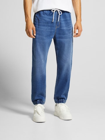 Bershka Tapered Jeans in Blue: front