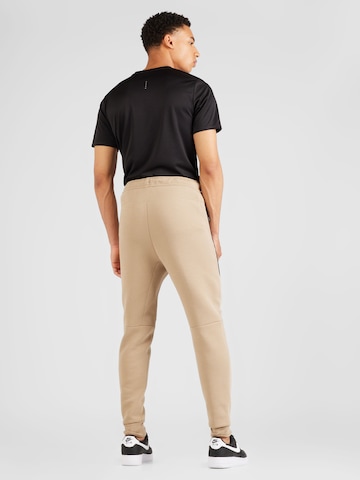 Nike Sportswear Zúžený Kalhoty 'Tech Fleece' – béžová