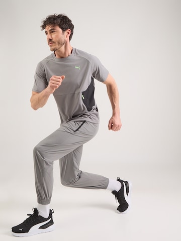 pelēks PUMA Pakapēniski sašaurināts piegriezums Sporta bikses 'PUMATECH'