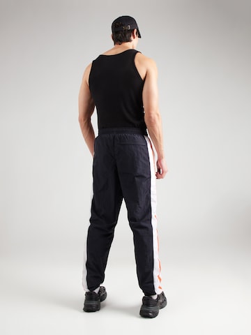 Effilé Pantalon de sport UNDER ARMOUR en noir