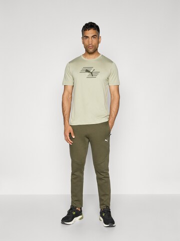 PUMA Slimfit Urheiluhousut 'Evostripe' värissä vihreä